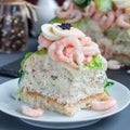 Piece of traditional savory swedish sandwich cake Smorgastorta with bread, shrimps, eggs, caviar, dill, mayonnaise, cucumber and