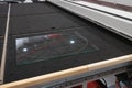 Piece of transparent glass lays on industrial CNC computer remote controlled glass cutter water-jet or laser system