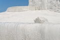 Piece of travertine on travertine terrace edge against blue sky