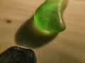 Piece of tumbled green glass aligned with piece of sea shell_Macro