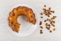 Piece of Viennese cake in white plate and scattered raisins