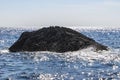 A piece of volcanic rock sticking out of the sparkling sea water off the coast of Zakynthos, Greece Royalty Free Stock Photo