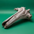 A piece of weathered driftwood rests on a solid green background Royalty Free Stock Photo