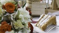 A piece of wedding cake on a white plate on floral decorated table Royalty Free Stock Photo