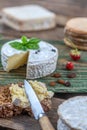 Piece and wheel of traditional Normandy soft cheese Camembert with country homemade bread, fresh aromatic herbs Royalty Free Stock Photo