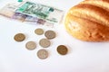 A piece of white bread, coins and paper rubles on the table. The concept of poverty, lack of money for food