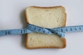 Piece of white bread measuring tape a light background