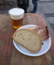 A piece of white bread and pork slice with a pint of lager in a plastic cup in a street in Prague Royalty Free Stock Photo