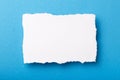 Piece of white paper with torn edges on a colored background with a place for text Royalty Free Stock Photo