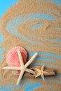 Piece of wood with beautiful starfishes and sand on blue background, flat lay. Space for text Royalty Free Stock Photo