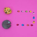 Piece of wood with an eye catches colorful ladybugs going towards the pumpkin on a pink background