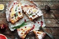 Pieces of apple pie sprinkled with powdered sugar. Homemade cut apple cake decorated slices of lemon and green spruce branches and Royalty Free Stock Photo