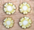 Pieces of baby corn look like flowers on a wooden surface