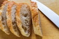 Pieces of Baguette Loaf of French Bread, on wooden board.