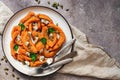 Pieces of baked pumpkin with herbs, seeds and cheese in a plate on a beige textured background. Top view, flat lay Royalty Free Stock Photo