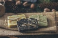 Pieces of beautiful natural handcrafted soap on wooden background with botanical elements, close up view.