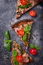 Pieces of black pizza with tomatoes and basil Royalty Free Stock Photo