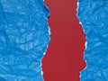 Pieces of blue paper torn and crumpled on a red background Royalty Free Stock Photo