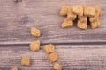 Pieces of brown cane sugar on a wooden background. Close up