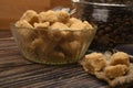 Pieces of brown sugar in a sugar bowl and coffee beans in a glass jar on a wooden background. Close up Royalty Free Stock Photo