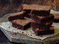 Pieces of cake chocolate brownies on wooden background.