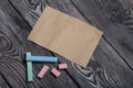Pieces of chalk for drawing, different colors. Paper. They lie on pine boards painted with white and black paint Royalty Free Stock Photo