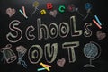 Pieces of chalk, stationery and text SCHOOL`S OUT written on blackboard, flat lay. Summer holidays Royalty Free Stock Photo