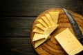 Pieces of cheese cut with a knife on a kitchen cutting board. Cheese tasting. Space for recipe or menu Royalty Free Stock Photo