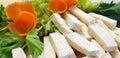 Pieces of cheese decorated with carrots.