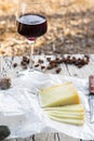 Pieces of cheese and raisins with a red wine glass on a old wood board Royalty Free Stock Photo