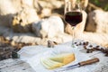 Pieces of cheese and raisins with a red wine glass on a old wood Royalty Free Stock Photo