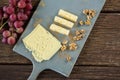 Pieces of cheese, walnut and grapes on chopping board Royalty Free Stock Photo