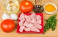 Pieces of chicken meat in red plate, tomatoes, spices, garlic Royalty Free Stock Photo