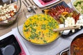 Pieces of chicken in a sauce with curry and coconut milk lying in a glass bowl with a wooden spoon in the center of the table fill Royalty Free Stock Photo