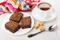Pieces of chocolate cake in plate, sugar, cup of tea