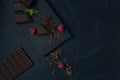 Pieces of chocolate, chocolate shavings, raspberry and mint on dark textured background. Top view. Flat lay. Copy space Royalty Free Stock Photo