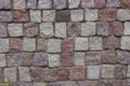 Pieces of cobblestones bricks cubes of granite red gray pink black, background texture. Granite masonry wall of an old building Royalty Free Stock Photo