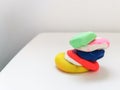 Pieces of colored plasticine collected in a pyramid on a white table