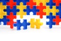 Pieces from a colorful jigsaw puzzle arranged to form a page on white background. Break barriers together for autism