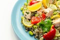 Pieces of cooked salmon and edamame soya beans with red pepper  and baby leaf spinach, served with brown long grain rice with Royalty Free Stock Photo