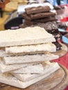 Pieces of crude white chocolate stacked on wooden chopping board