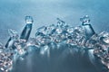 Pieces of crushed ice cubes in the in the form of an arc with long shadows and reflections on the surface on a blue Royalty Free Stock Photo