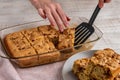 Pieces of cut apple pie from a bowl are laid out on a plate. Close-up of a woman\'s hand with a spatula tak Royalty Free Stock Photo