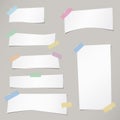 Pieces of cut white note paper are stuck with striped sticky tape on gray background Royalty Free Stock Photo