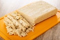 Pieces of cutted peanut halva on plastic cutting board on wooden table