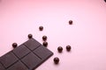 Pieces of dark chocolate bar and milk chocolate pearls on pink background, top view, copy space Royalty Free Stock Photo