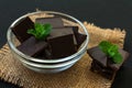 Pieces of dark chocolate and mint on a black background. Close-up. Royalty Free Stock Photo