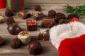 Pieces of delicious assorted chocolates are coming out of a christmas stocking on wooden table Royalty Free Stock Photo