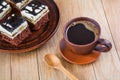 Pieces of delicious chocolate cake with cream and chocolate fondant in a plate and a cup of coffee on a wooden table Royalty Free Stock Photo