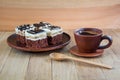 Pieces of delicious chocolate cake with cream and chocolate fondant in a plate and a cup of coffee on a wooden table Royalty Free Stock Photo